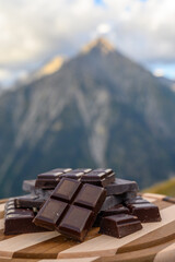 Handmade pure dark swiss chocolate and Alpine mountains on background