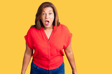 Middle age latin woman wearing casual clothes scared and amazed with open mouth for surprise, disbelief face