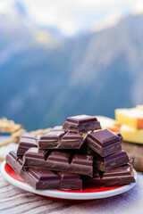 Handmade pure dark swiss chocolate and Alpine mountains on background