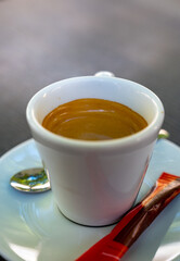 Drinking of strong black espresso coffee on outdoor terrace in cafe