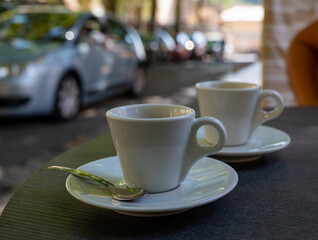 Drinking of strong black espresso coffee on outdoor terrace in cafe