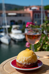 Summer is Provence, tasty dessert with small yellow lemon ball tart and french cold rose wine and marina with yachts and sailboats on background