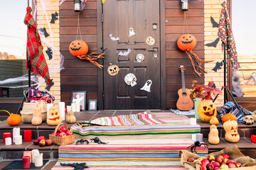 Door of country house decorated with halloween symbols in front of staircase