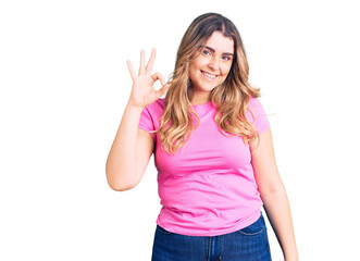 Obraz na płótnie Canvas Young caucasian woman wearing sportswear smiling positive doing ok sign with hand and fingers. successful expression.