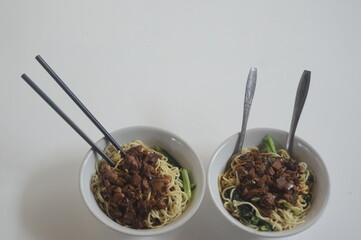 Chicken noodles with green mustard greens. served in a bowl. typical asian food