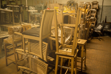 Photo of a furniture warehouse . A mountain of wooden chairs.