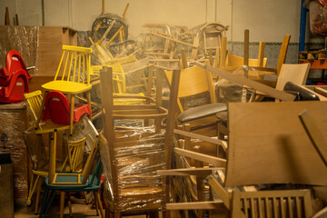 Photo of a furniture warehouse . A mountain of wooden chairs.