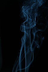 Fototapeta premium blue smoke from incense on a black background