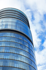 Fototapeta premium fragment of a high-rise, round, glass building, business center, modern urban architecture