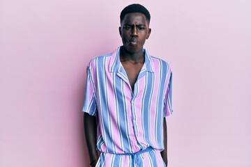 Young african american man wearing casual clothes making fish face with mouth and squinting eyes, crazy and comical.