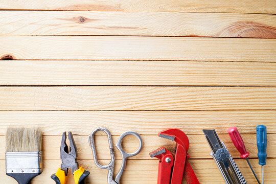 handyman and repairman accessories for repairing on a wooden desk background. domestic problems adjusting conceptual. above view. frame border