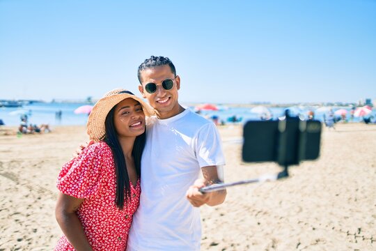 Young latin couple smiling happy making selfie by the smartphone at the beach.