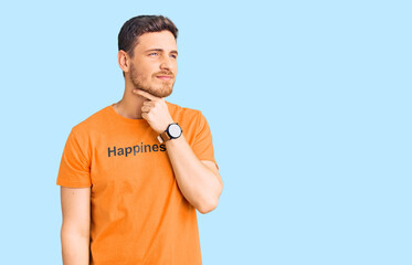 Handsome young man with bear wearing tshirt with happiness word message touching painful neck, sore...
