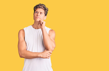 Young handsome man wearing sleveeless t shirt serious face thinking about question with hand on...