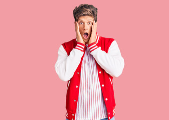 Young handsome man wearing baseball uniform afraid and shocked, surprise and amazed expression with hands on face