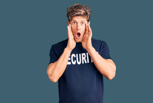 Young handsome man wearing security t shirt afraid and shocked, surprise and amazed expression with hands on face