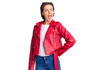 Young beautiful woman wearing red leather jacket winking looking at the camera with sexy...