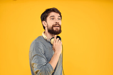 Fototapeta premium Man in headphones listens to music technology lifestyle fun people yellow background