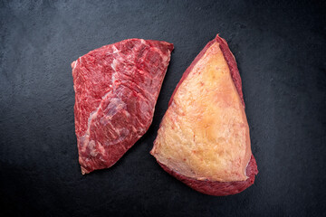 Raw dry aged wagyu cap of rump beef offered as top view on black background with copy space