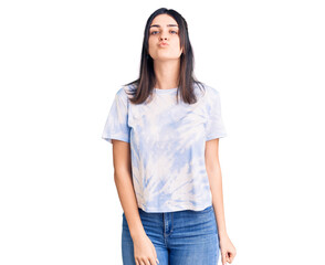 Young beautiful girl wearing casual t shirt looking at the camera blowing a kiss on air being lovely and sexy. love expression.