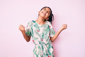 Young african american girl child with braids wearing summer style very happy and excited doing winner gesture with arms raised, smiling and screaming for success. celebration concept.