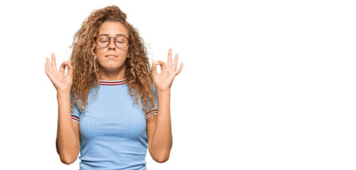 Beautiful caucasian teenager girl wearing casual clothes and glasses relax and smiling with eyes closed doing meditation gesture with fingers. yoga concept.