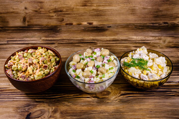 Set of festive mayonnaise salads on wooden table
