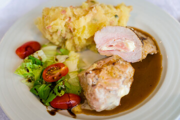 Stuffed meat with side dish and mashed potatoes.