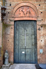 Morbide hölzerne Kirchentür unter Bogen mit Relief