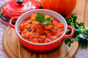 Vegetable stew in a beautiful red saucepan.