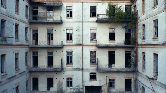 Abandoned ruined 19th century apartment building with a yard-well (courtyard). Broken windows in a deserted old house. Aerial view