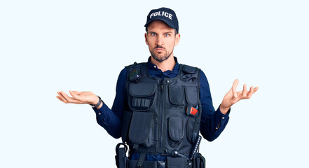 Young handsome man wearing police uniform clueless and confused with open arms, no idea concept.