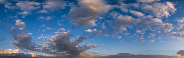 Summer sunset sky panorama with fleece colorful clouds. Evening dusk good weather natural background.