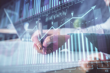 Double exposure of forex chart drawing over people taking notes background. Concept of financial analysis