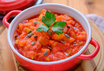 Vegetable stew in a beautiful red saucepan.