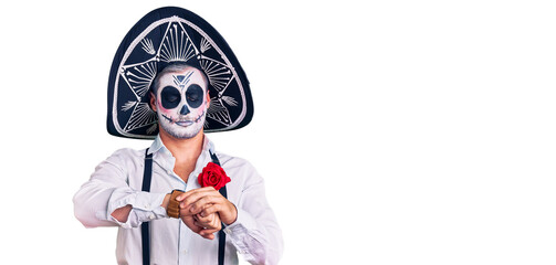 Man wearing day of the dead costume over background checking the time on wrist watch, relaxed and confident