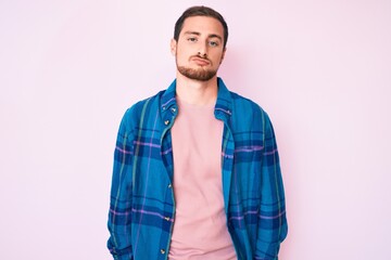 Fototapeta premium Young handsome man wearing casual clothes looking sleepy and tired, exhausted for fatigue and hangover, lazy eyes in the morning.