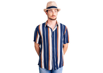 Young handsome caucasian man wearing summer hat smiling looking to the side and staring away thinking.