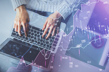 Multi exposure of woman hands working on computer and forex chart hologram drawing. Top View. Financial analysis concept.