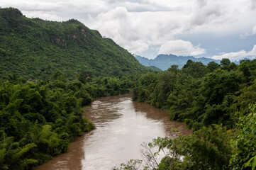 Naklejka na ściany i meble Thailand landscape with trees, mountains and a river.
