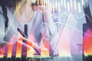 Double exposure of woman hands typing on computer and financial graph hologram drawing. Stock market analysis concept.