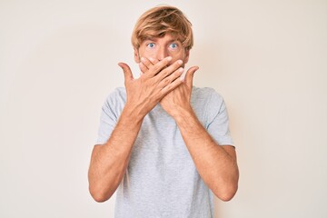 Young blond man wearing casual clothes shocked covering mouth with hands for mistake. secret concept.