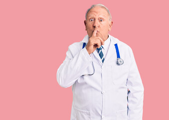Senior handsome grey-haired man wearing doctor coat and stethoscope asking to be quiet with finger...