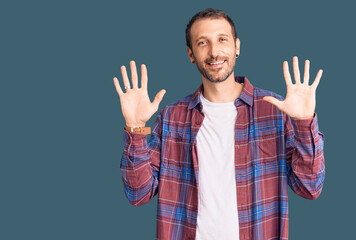 Young handsome man wearing casual clothes showing and pointing up with fingers number ten while smiling confident and happy.