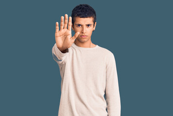 Young african amercian man wearing casual clothes doing stop sing with palm of the hand. warning expression with negative and serious gesture on the face.