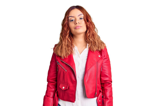 Young latin woman wearing red leather jacket with serious expression on face. simple and natural looking at the camera.
