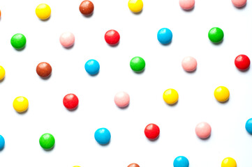 Colored balls of sugar on a white background. Chocolate candies covered with multicolored sugar glaze.