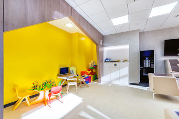 The waiting area with tea and coffee point, and the play space for children..Bright yellow play...