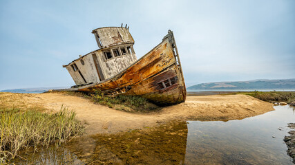 Landscape, an abandoned old ship lies aground, on the coast, California