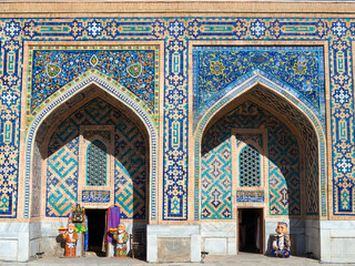 Two pishtaq and spandrel with detailed mosaic at Samarkand, Uzbekistan. Islamic architecture with a pair of iwans and colorful ceramic tiles. Tilya Kori Madrasah facade.